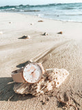 kurakura jeruk mawar, rosa Armband und rosa Weltkarte auf einem Stein am Strand